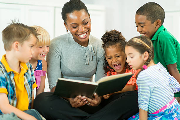 Story Time Teacher reading students a story book. teach reading to kindergarteners stock pictures, royalty-free photos & images