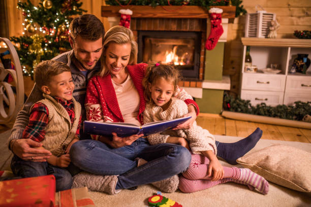 Storytelling on Christmas Eve! Young happy family reading fairy tales while relaxing at home during Christmas holidays. christmas story telling stock pictures, royalty-free photos & images