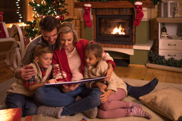 Storytelling on Christmas Eve! Young happy family reading fairy tales while relaxing at home during Christmas holidays. christmas story telling stock pictures, royalty-free photos & images