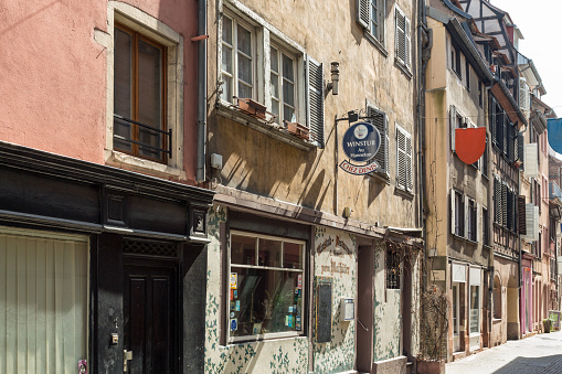 Strasbourg, France - April 8, 2015: The Rue Sainte-Madeleine is located in the quarter Krutenau in the french city Strasbourg, Bas-Rhin, Alsace, France. A small picturesque alley with old houses. Facades, doors and windows of the houses with advertising, menues and small logos. In the center the Restaurant \