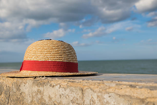 Straw hat with red ribbon near sea stock photo