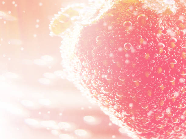 Strawberries in a glass container with bubbles in neon toning with gradient. stock photo