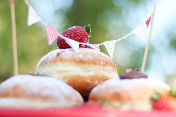 Strawberry atop a chocolate filled donut - outdoors with bunting stock photo