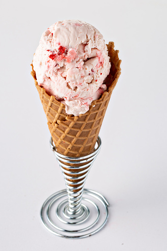 Strawberry ice cream in a waffle cone