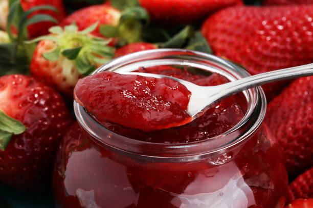 strawberry jam with fresh strawberries. marmalade on spoon and jar stock photo