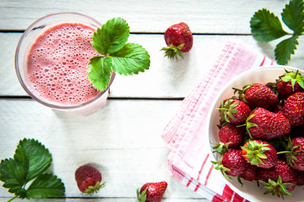 Strawberry Smoothie Strawberry Smoothie on a rustic wooden table strawberry smoothie stock pictures, royalty-free photos & images