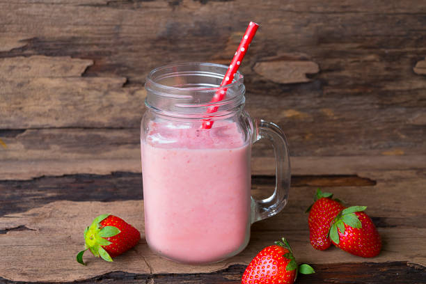 Strawberry smoothies colorful fruit juice milkshake blend beverage healthy high protein the taste yummy In glass drink episode morning on wood background. Strawberry smoothies colorful fruit juice milkshake blend beverage healthy high protein the taste yummy In glass drink episode morning on wood background. strawberry smoothie stock pictures, royalty-free photos & images