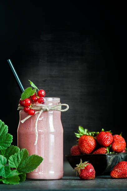 Strawberry somoothie Strawberry somoothie on a rustick black background strawberry smoothie stock pictures, royalty-free photos & images