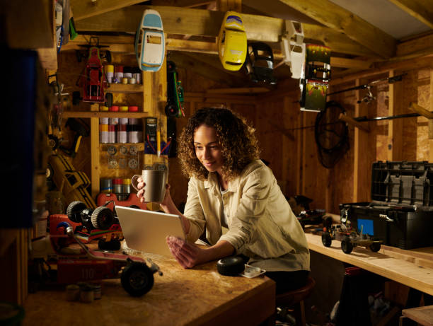 streaming in the workshop woman in her shed working on remote control cars screwdriver drink stock pictures, royalty-free photos & images