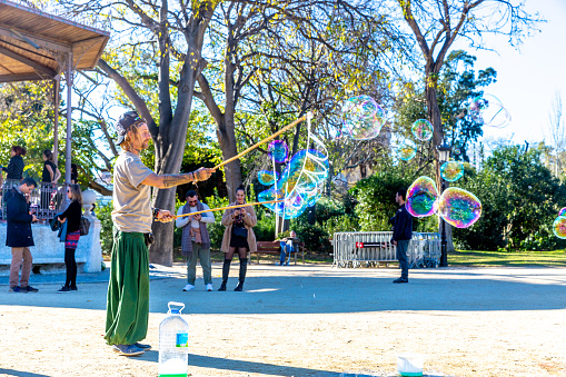 15/12/2019, in Parc de La Ciutadella, Barcelona, Spain: A street artist makes a soap bubble show for children to receive donations from their parents.