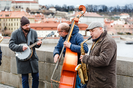 ストリートバンドのミュージシャンはプラハの中心部にあるカレル橋でチェロサクセフォンバンジョーを演奏します アコースティック音楽のストックフォトや画像を多数ご用意 Istock