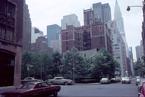 Midtown Manhattan, New York City, NY, USA, 1964. Street corner in New York City. Also: parked cars, a small park, office buildings and apartment buildings.