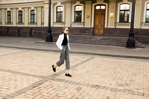 Kiev Oblast, UKRAINE - May 20, 2017: A beautifully dressed young woman is walking in front of the Diplomatic Academy of Ukraine.