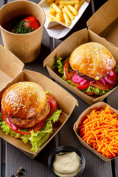 Street food. Meat cutlet burgers are in paper boxes. Food delivery. stock photo