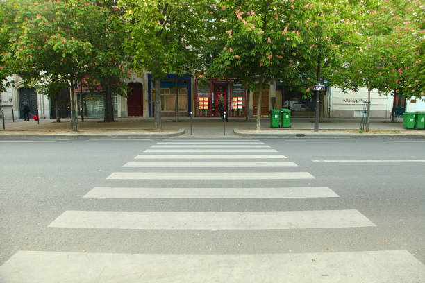 Street in Paris Large pedestrian crossing over a large and empty street in Paris, France crosswalk stock pictures, royalty-free photos & images
