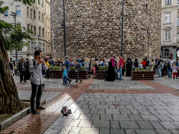 een straatmuzikant voor een rij toeristen bij de toren galata in istanboel. veel mensen op het oude historische plein - karaköy istanbul stockfoto's en -beelden