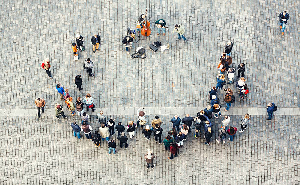 Street Musicians In Prague Prague, Czech Republic - April 24, 2014: View on performing street musicians and the audience from the top of Astronomical Clock Tower in Prague. Tourists are forming the circle on the Old Town Square. prague old town square stock pictures, royalty-free photos & images