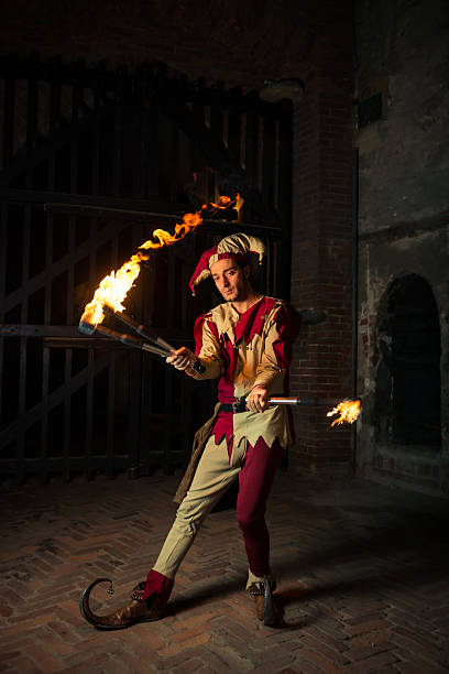 Street performer The Joker Street performer dressed as joker play with torches jester stock pictures, royalty-free photos & images
