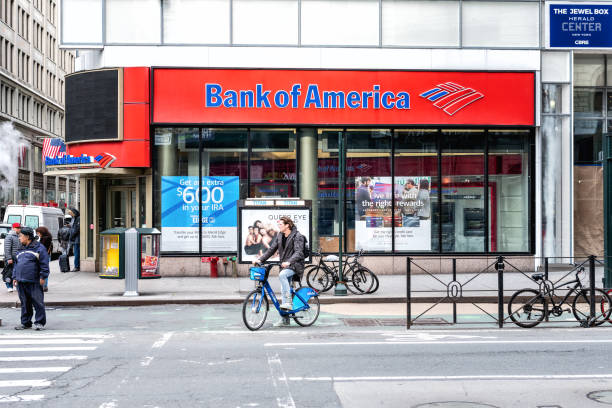 Street view on Bank of America branch in NYC with people waiting, pedestrians crossing, crosswalk, bike, road in Manhattan New York, USA - April 7, 2018: Street view on Bank of America branch in NYC with people waiting, pedestrians crossing, crosswalk, bike, road in Manhattan bank of america stock pictures, royalty-free photos & images