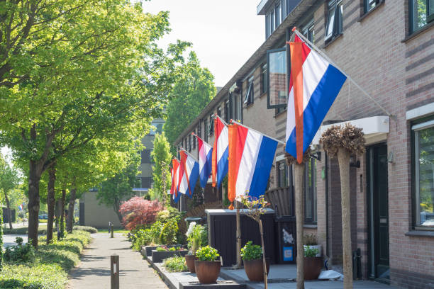 straße mit holländischen flaggen, die am kingsday draußen hängen - holländische flagge stock-fotos und bilder