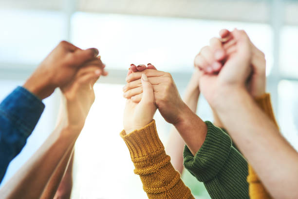 Strength in numbers Closeup shot of a diverse group of people holding hands together in unity group therapy stock pictures, royalty-free photos & images