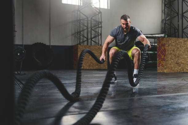 Strengthen and sweat Shot of a man training with heavy ropes at the gym. battle stock pictures, royalty-free photos & images