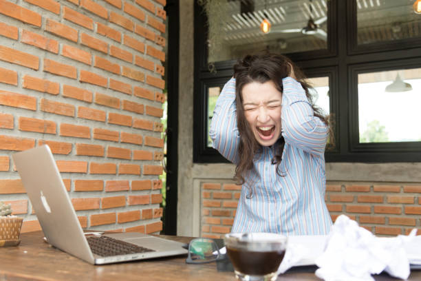 Stress female screaming with shock, woman serious with laptop computer problem.Girl in panic with her project deadline stock photo