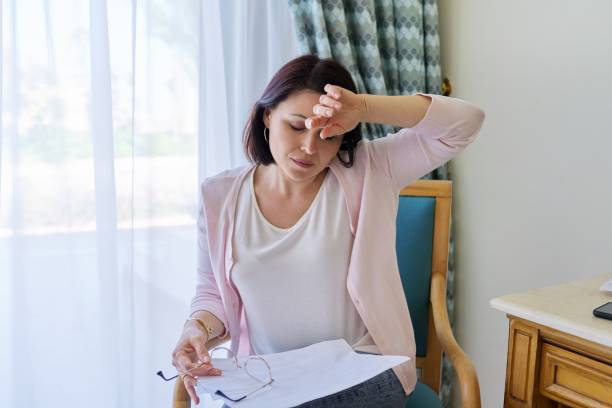 Stress, headache, migraine, upset middle-aged woman holding her head with her hands stock photo