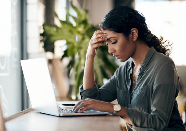 Stress management is a must for solo entrepreneurs Shot of a young woman experiencing stress while working in a cafe banging your head against a wall stock pictures, royalty-free photos & images
