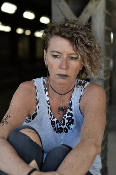 stressed mature punk lady looking thoughtfully down stock photo