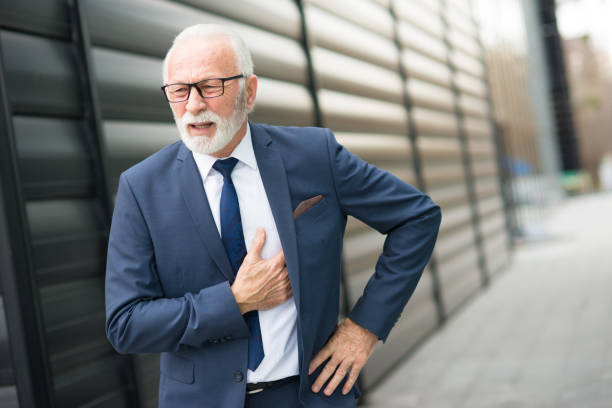 Stressed out senior businessman having heart attack stock photo