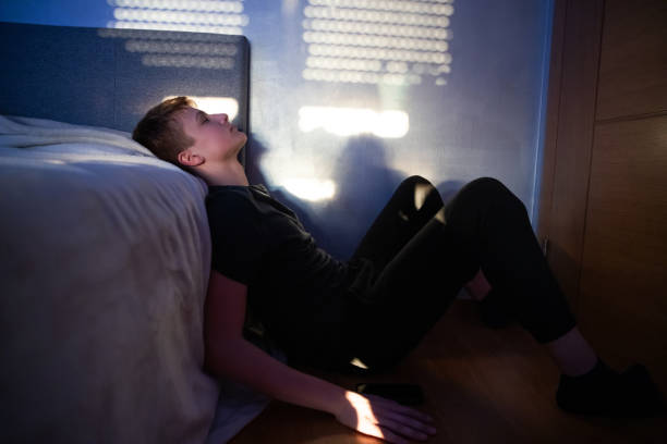 Stressed Out Teenager Boy in a Dark Room stock photo