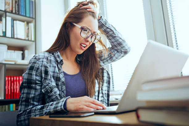 Stressed Student Doing Homework in library Stressed Student Doing Homework hardest exams stock pictures, royalty-free photos & images