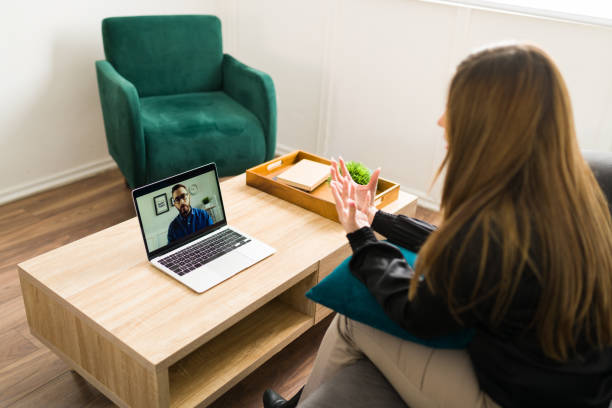 Stressed woman talking with a virtual therapist stock photo