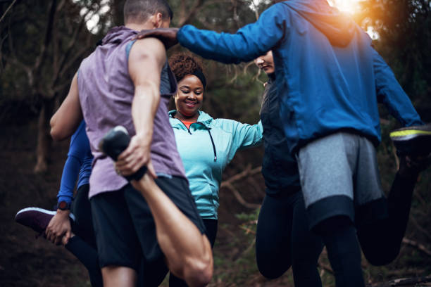 Stretching together and helping one another Cropped shot of a sporty young group of friends working out in the forest execise in hectic life stock pictures, royalty-free photos & images