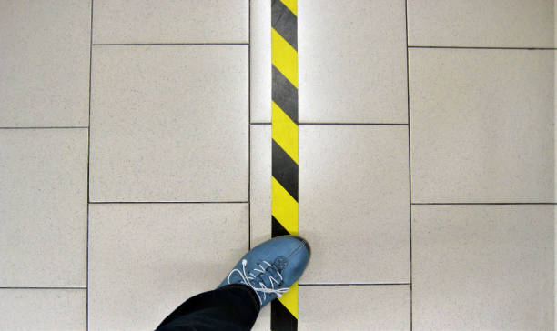 striped dividing line on the floor to maintain distance stock photo