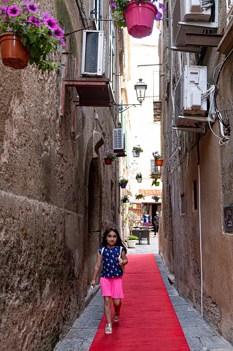 A Little girl walking trought a tiny street of Tropea