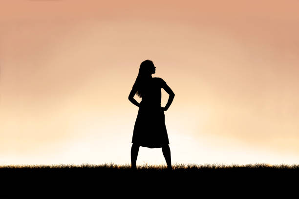 Strong Beautiful Woman Silhouette Isolated Against Sunset Sky Background stock photo