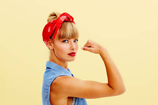 強力な金髪の女性屈曲の筋肉 - ガールパワー ストックフォトと画像