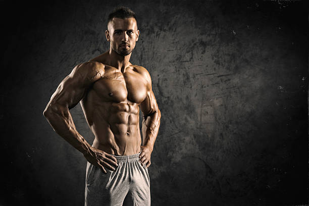 Strong Muscular Men Portrait of a physically fit, muscular young man without a shirt.  body building stock pictures, royalty-free photos & images