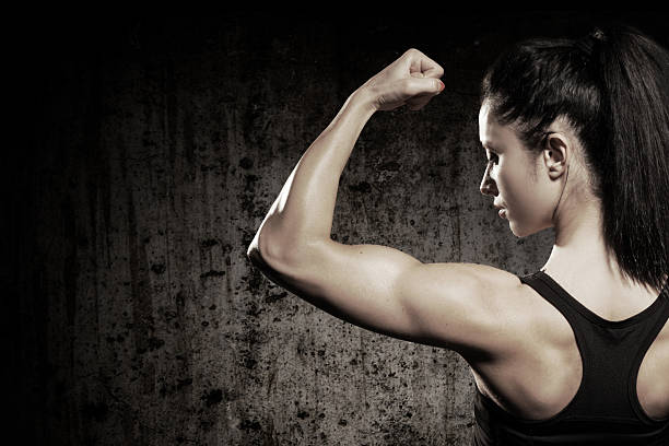 A strong woman flexing her muscles stock photo