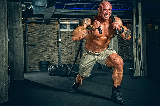Strongman Training Strong Muscular Men pulling big tire with ropes bodybuilding stock pictures, royalty-free photos & images