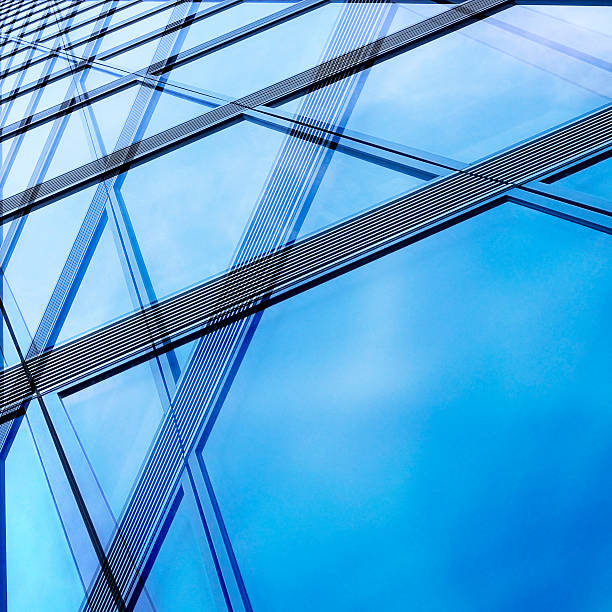 Structural / modular glass wall reflecting bright sky Structural / modular glass wall reflecting bright sky. Hi-tech architectural background composition with environmental motif. architectural feature stock pictures, royalty-free photos & images