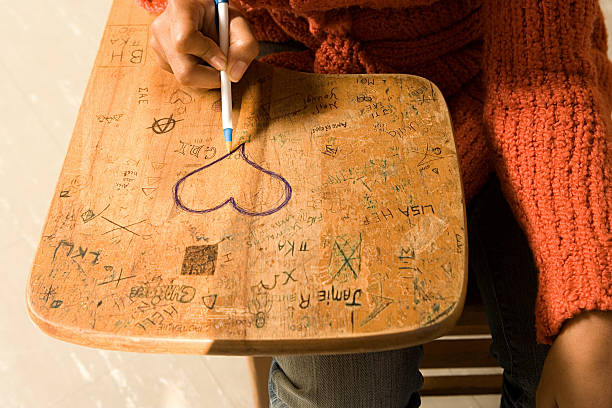 Student drawing a heart on her desk stock photo