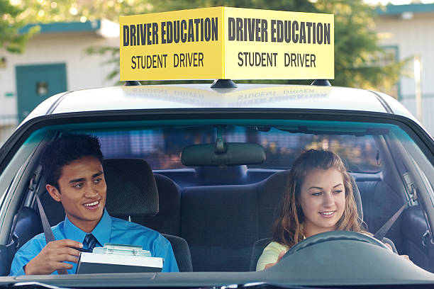 A student driver with her driving instructor Student driver taking a driver education course. gchutka stock pictures, royalty-free photos & images