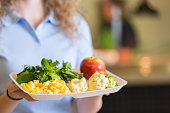 Student holding tray of healthy food in school cafeteria lunchroom