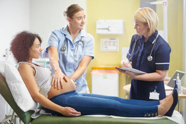 student midwife learning a pregnant lady is examined by young student midwife overseen by a senior nurse midwife stock pictures, royalty-free photos & images