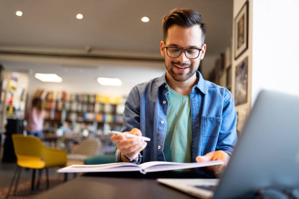Student preparing exam and learning lessons in school library stock photo