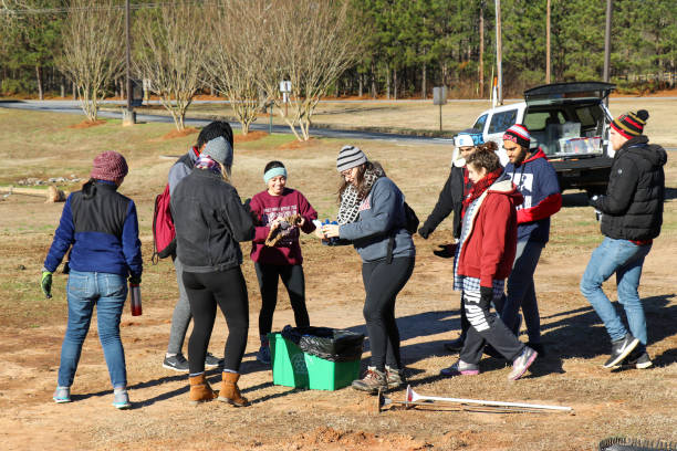 Student volunteers plant trees for 2019 MLK Day of Service in Winterville, Georgia. Winterville, Georgia - January 21, 2019: Student volunteers participating in the MLK Day of Service donning gloves before planting trees at the Winterville Elementary School. martin luther king jr day stock pictures, royalty-free photos & images