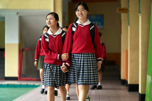 studenten die handen vasthouden tijdens het lopen op school - hogeschool rood samen stockfoto's en -beelden